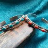 Pulsera tibetana abierta con piedras rojas y azules con relieve floral